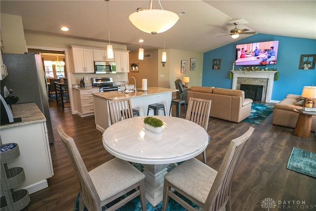 1331 Peregrine Way, Hamilton, OH 45013 - dining area with ceiling fan, dark wood-type flooring, vaulted ceiling, a fireplace, and recessed lighting