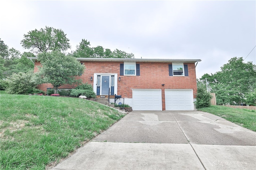 734 Mcguire Cir, Miamisburg, OH 45342 - bi-level home with brick siding, a garage, driveway, and a front yard
