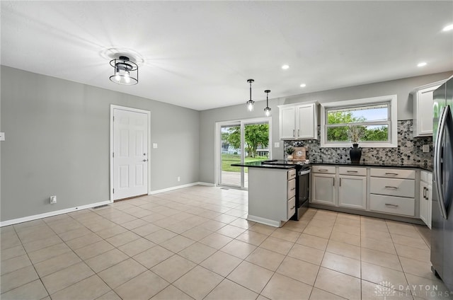 3040 Fontano Dr, Kettering, OH 45440 - kitchen with a peninsula, plenty of natural light, decorative backsplash, dark countertops, and recessed lighting