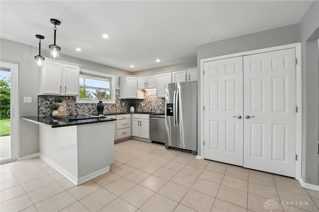 3040 Fontano Dr, Kettering, OH 45440 - kitchen featuring stainless steel appliances, a peninsula, dark countertops, backsplash, and white cabinets