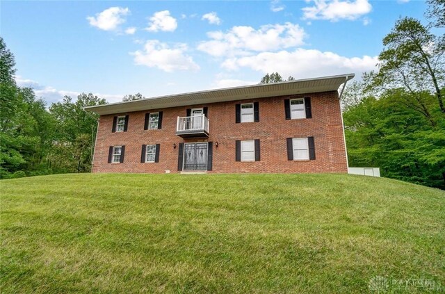 5829 Watt Rd, Camden, OH 45311 - view of front of home featuring a front yard, a balcony, and brick siding