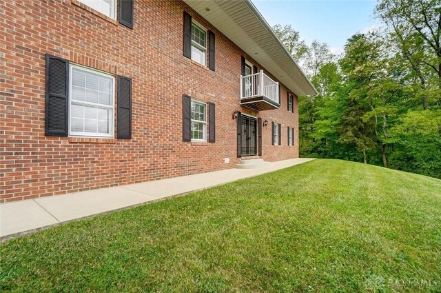 5829 Watt Rd, Camden, OH 45311 - rear view of house featuring a balcony, a yard, and brick siding