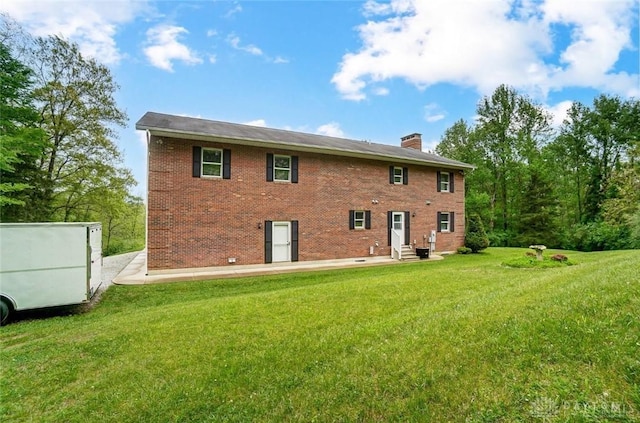 5829 Watt Rd, Camden, OH 45311 - back of house featuring entry steps, a chimney, brick siding, and a lawn