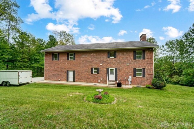 5829 Watt Rd, Camden, OH 45311 - back of house with entry steps, a chimney, a lawn, and central air condition unit