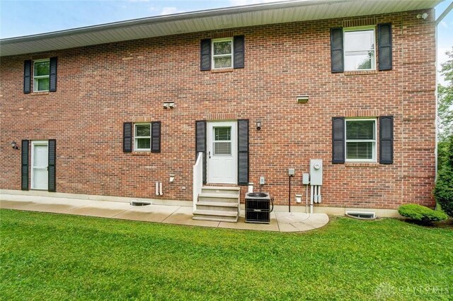 5829 Watt Rd, Camden, OH 45311 - back of property featuring entry steps, a yard, brick siding, central AC unit, and a patio area