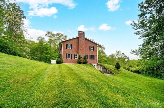 5829 Watt Rd, Camden, OH 45311 - back of property featuring a chimney, a lawn, and brick siding