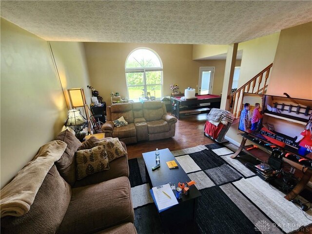 2380 Patterson Ln, Troy, OH 45373 - living area featuring a textured ceiling, wood finished floors, and stairway