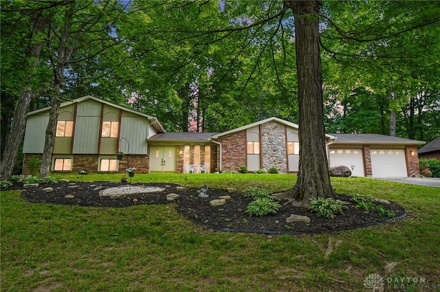 2942 Stauffer Dr, Beavercreek, OH 45434 - split level home featuring a front lawn, brick siding, and a garage