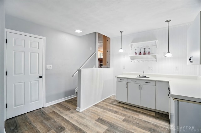 2942 Stauffer Dr, Beavercreek, OH 45434 - kitchen featuring light wood-style flooring, pendant lighting, light countertops, a sink, and open shelves