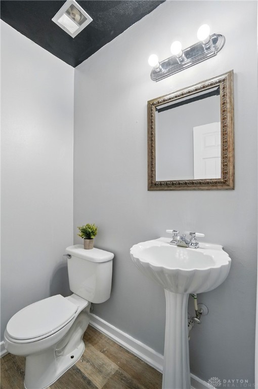 2942 Stauffer Dr, Beavercreek, OH 45434 - half bathroom featuring wood finished floors, toilet, and baseboards