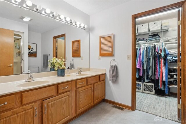 1462 Dee Anne Dr, Xenia, OH 45385 - full bath featuring double vanity, a stall shower, a spacious closet, baseboards, and toilet