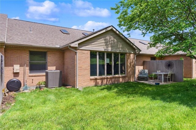 1462 Dee Anne Dr, Xenia, OH 45385 - back of property with central air condition unit, brick siding, a shingled roof, and a patio area