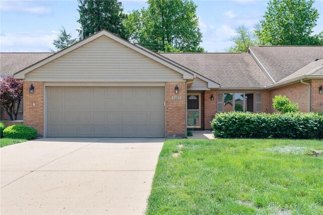 1462 Dee Anne Dr, Xenia, OH 45385 - ranch-style home with brick siding, roof with shingles, an attached garage, concrete driveway, and a front yard