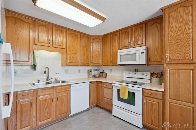 1462 Dee Anne Dr, Xenia, OH 45385 - kitchen with white appliances, a sink, backsplash, and brown cabinets