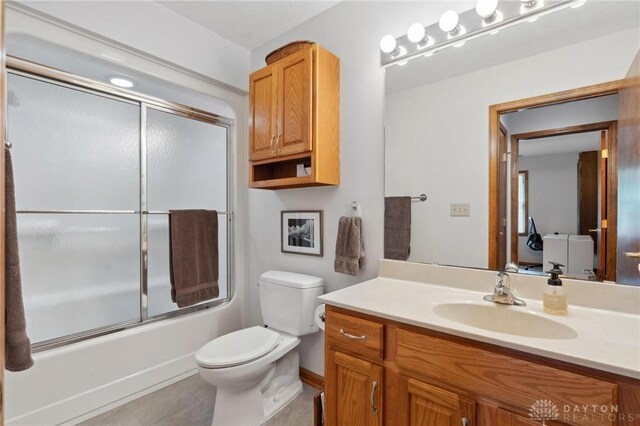 1462 Dee Anne Dr, Xenia, OH 45385 - full bathroom featuring vanity, toilet, shower / bath combination with glass door, tile patterned floors, and baseboards