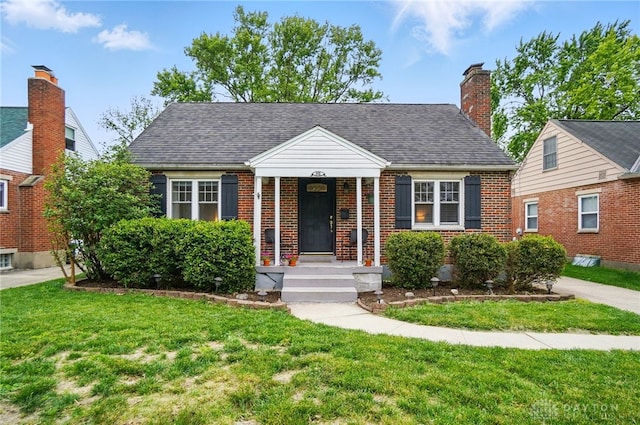 448 Triangle Ave, Oakwood, OH 45419 - bungalow with a front yard, brick siding, a shingled roof, and covered porch