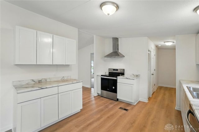 665 Diamond Loop, Middletown, OH 45044 - kitchen with stainless steel appliances, wall chimney range hood, light wood finished floors, white cabinetry, and baseboards