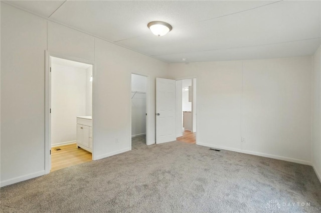 665 Diamond Loop, Middletown, OH 45044 - unfurnished bedroom with light carpet, a spacious closet, connected bathroom, baseboards, and a closet