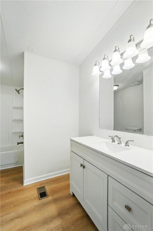665 Diamond Loop, Middletown, OH 45044 - bathroom featuring vanity, wood finished floors, shower / tub combination, and baseboards