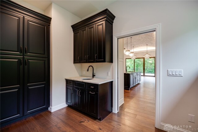 6481 Stagecoach Way, Liberty Twp, OH 45011 - bar area featuring a chandelier, a sink, dark wood-style floors, and baseboards