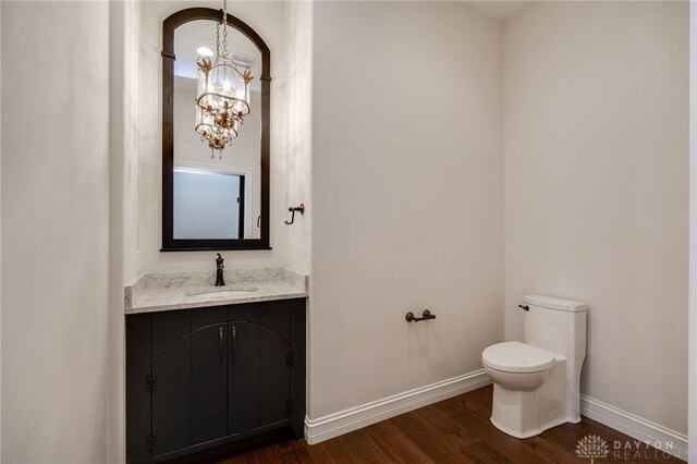 6481 Stagecoach Way, Liberty Twp, OH 45011 - half bathroom featuring a chandelier, toilet, wood finished floors, vanity, and baseboards
