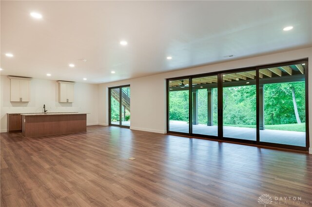 6481 Stagecoach Way, Liberty Twp, OH 45011 - unfurnished living room featuring recessed lighting, baseboards, wood finished floors, and a sink
