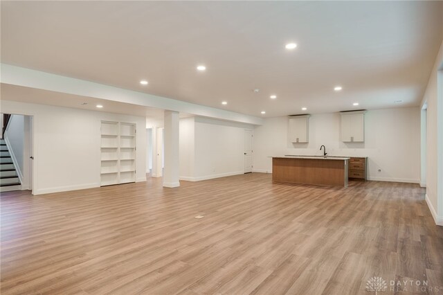 6481 Stagecoach Way, Liberty Twp, OH 45011 - unfurnished living room with baseboards, stairs, recessed lighting, a sink, and light wood finished floors