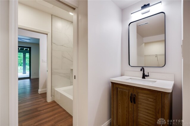 6481 Stagecoach Way, Liberty Twp, OH 45011 - bathroom with wood finished floors, vanity, a tub, baseboards, and a shower