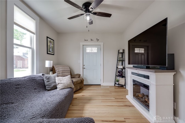 602 W N St, Arcanum, OH 45304 - living area featuring light wood finished floors, a ceiling fan, and a glass covered fireplace