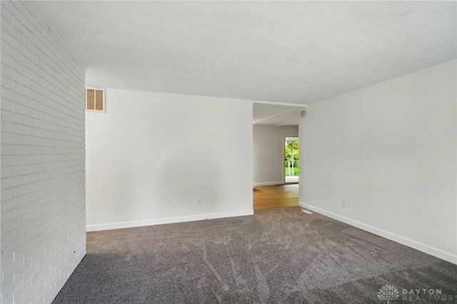 2424 Pinegrove Dr, Dayton, OH 45449 - carpeted spare room featuring baseboards and brick wall