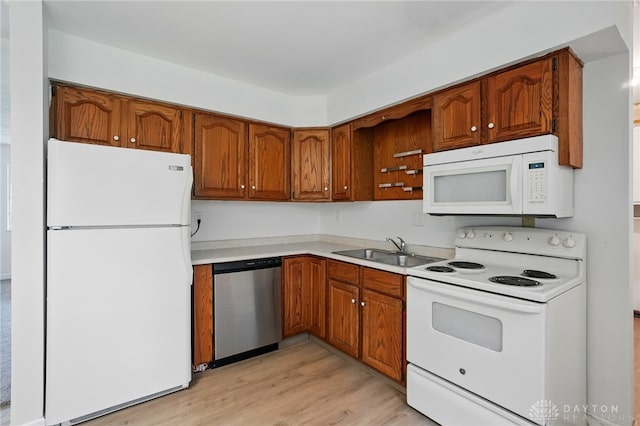 2424 Pinegrove Dr, Dayton, OH 45449 - kitchen featuring white appliances, a sink, brown cabinetry, light wood-type flooring, and light countertops