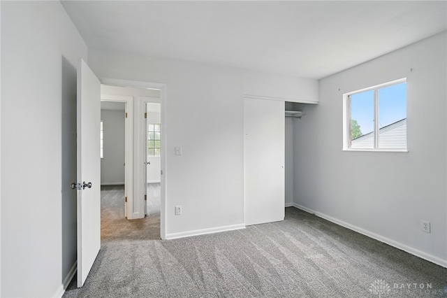 2424 Pinegrove Dr, Dayton, OH 45449 - unfurnished bedroom featuring multiple windows, carpet floors, baseboards, and a closet