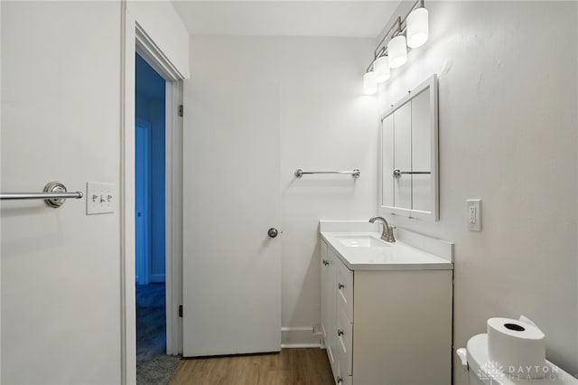 2424 Pinegrove Dr, Dayton, OH 45449 - half bath featuring vanity, toilet, and wood finished floors