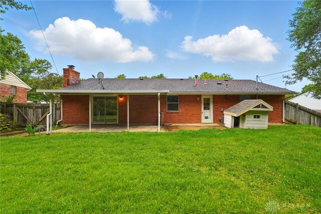 2424 Pinegrove Dr, Dayton, OH 45449 - back of property featuring a patio area, a chimney, and brick siding