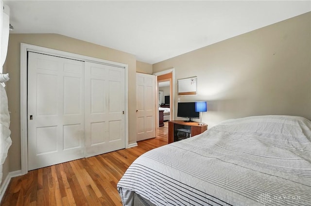 5571 Hugh Dr, Dayton, OH 45459 - bedroom with light wood finished floors, a closet, lofted ceiling, and baseboards