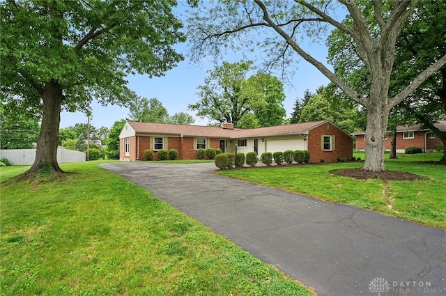 5571 Hugh Dr, Dayton, OH 45459 - ranch-style house with driveway, an attached garage, brick siding, and a chimney
