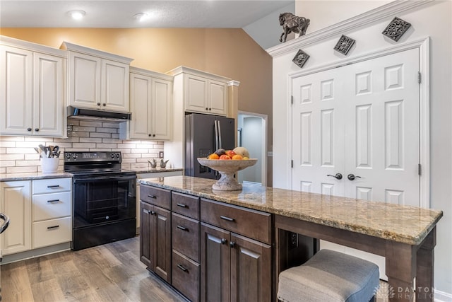 2182 Sharon View Ct, Lebanon, OH 45036 - kitchen featuring black range with electric cooktop, freestanding refrigerator, vaulted ceiling, under cabinet range hood, and tasteful backsplash