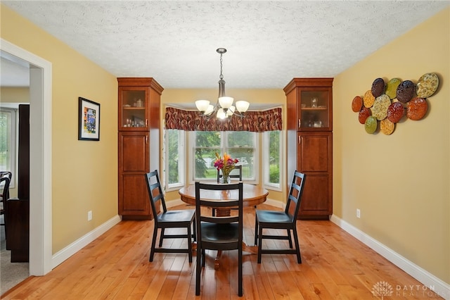 10550 Willow Brook Rd, Dayton, OH 45458 - dining room featuring a chandelier, light wood-type flooring, baseboards, and a textured ceiling