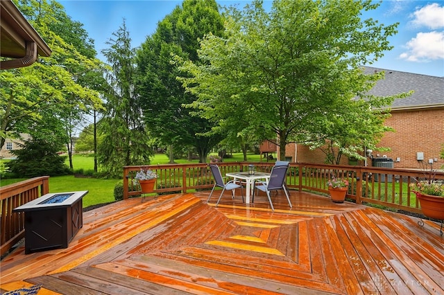 10550 Willow Brook Rd, Dayton, OH 45458 - wooden deck featuring an outdoor fire pit, outdoor dining space, a lawn, and central air condition unit