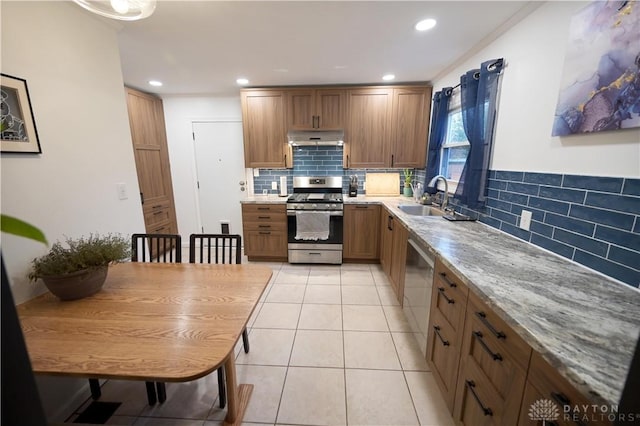 1265 Jeanette Dr, Dayton, OH 45432 - kitchen with stainless steel appliances, under cabinet range hood, a sink, tasteful backsplash, and brown cabinets