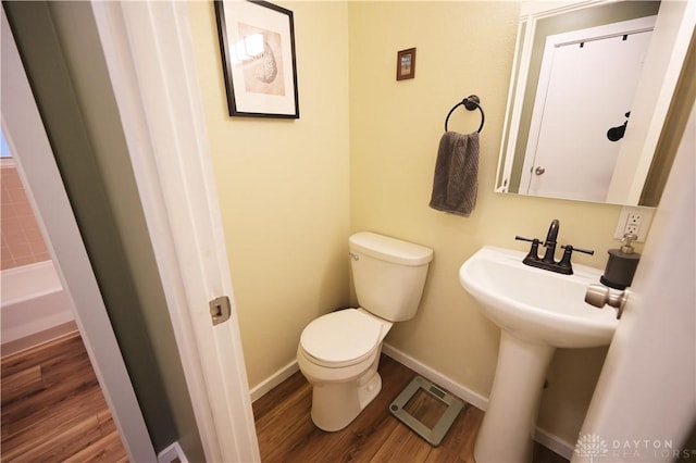 1265 Jeanette Dr, Dayton, OH 45432 - bathroom featuring toilet, wood finished floors, baseboards, and a bathtub