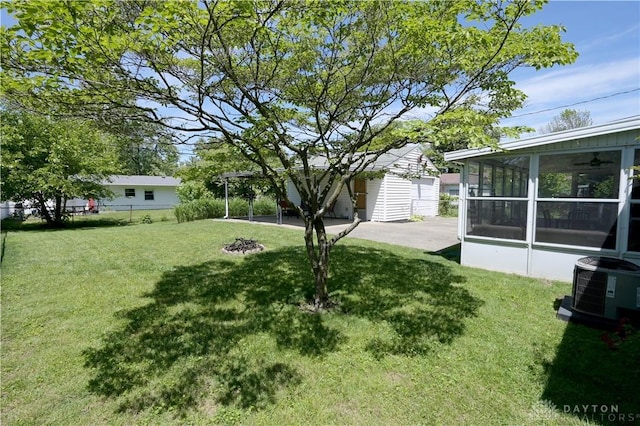1265 Jeanette Dr, Dayton, OH 45432 - view of yard with a sunroom, central AC unit, and an outdoor structure