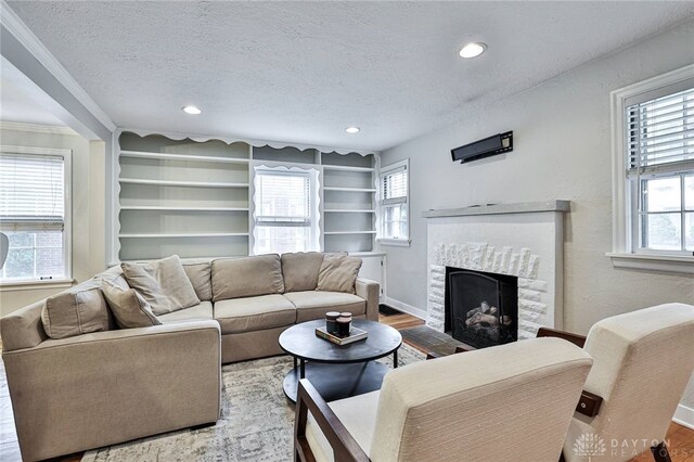 407 Claranna Ave, Oakwood, OH 45419 - living area featuring a textured ceiling, a fireplace, wood finished floors, recessed lighting, and built in shelves