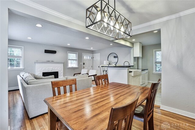 407 Claranna Ave, Oakwood, OH 45419 - dining space with a fireplace, plenty of natural light, ornamental molding, light wood-style floors, and recessed lighting