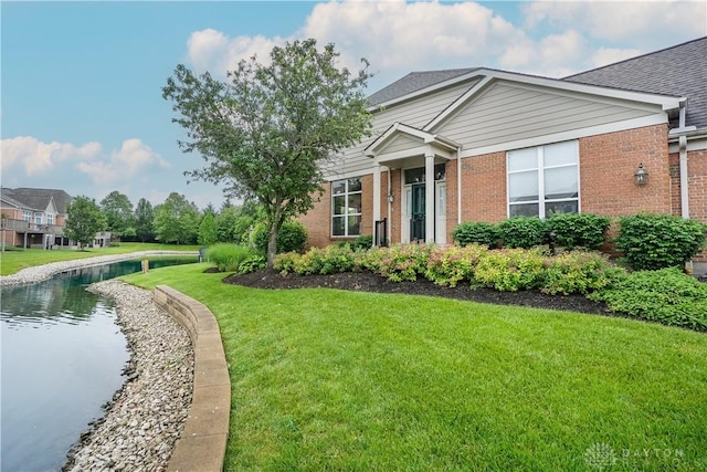 7516 Blue Fox Run, West Chester, OH 45069 - view of front of house with brick siding, a front yard, and a water view