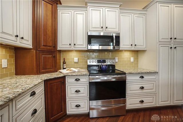 7516 Blue Fox Run, West Chester, OH 45069 - kitchen featuring stainless steel appliances, decorative backsplash, white cabinetry, and light stone counters