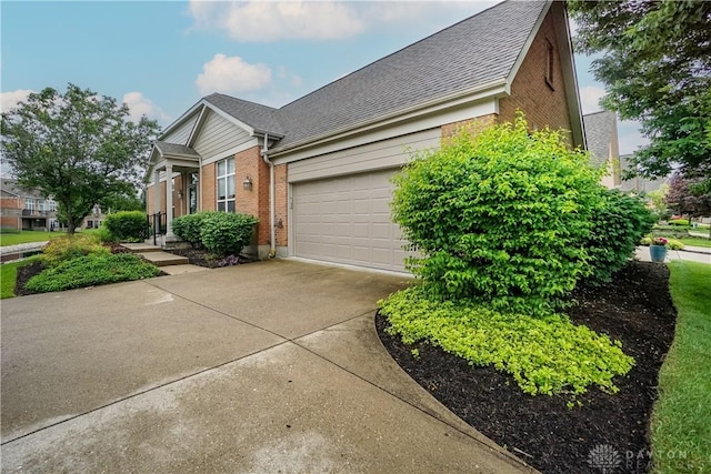 7516 Blue Fox Run, West Chester, OH 45069 - view of side of property with brick siding, driveway, a garage, and a shingled roof