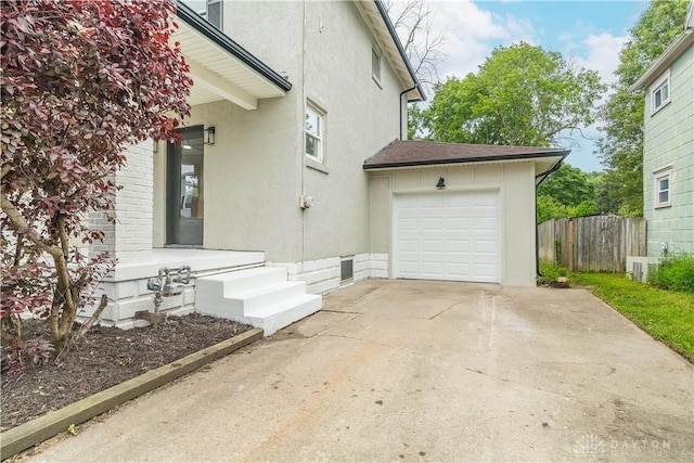 522 Pennsylvania Ave, Troy, OH 45373 - view of property exterior featuring driveway, an attached garage, stucco siding, and a shingled roof