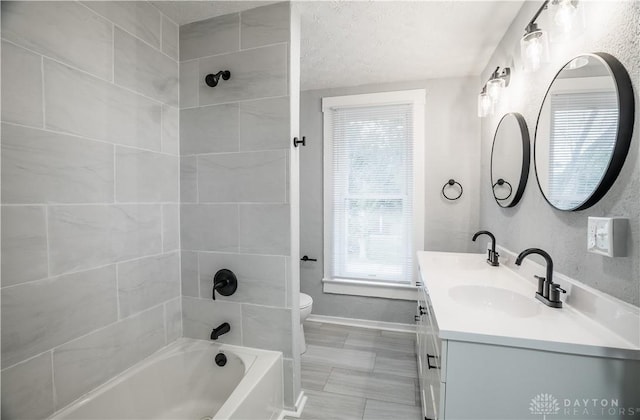 522 Pennsylvania Ave, Troy, OH 45373 - bathroom with vanity, toilet, washtub / shower combination, baseboards, and a textured ceiling