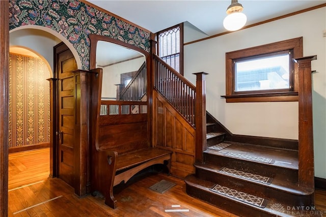 1628 E 5th St, Dayton, OH 45403 - stairway featuring wallpapered walls, wood finished floors, baseboards, ornamental molding, and arched walkways